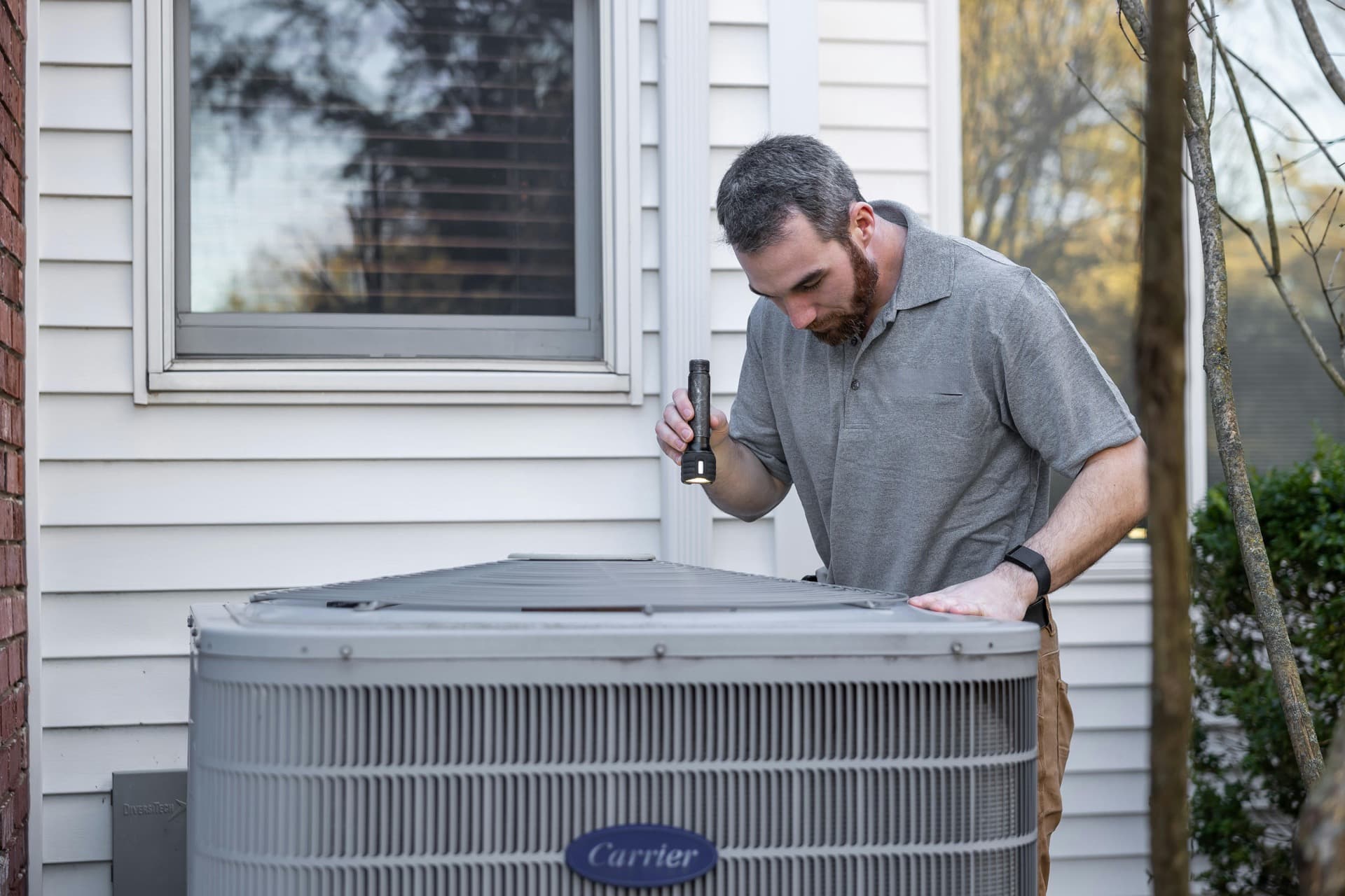 Technician inspecting a residential air conditioning unit